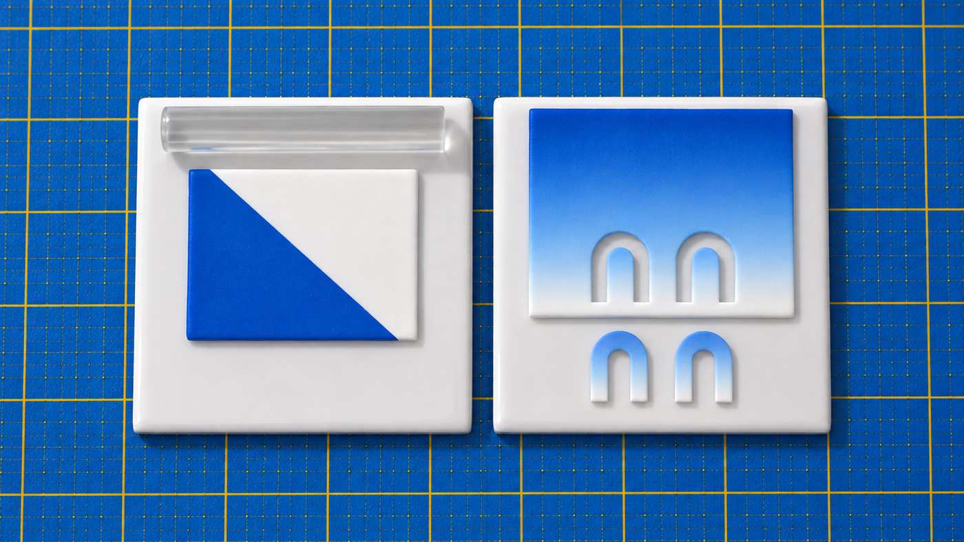 A blue and white polymer clay sheet joined along a sloping line, next to a finished blue-to-white Skinner blend sheet with two matching arch earrings cut across the fade.