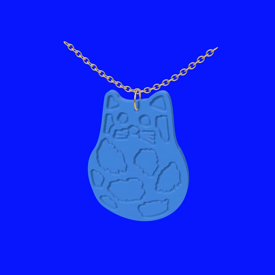 A relief cat hanging from a jump ring on a chain.