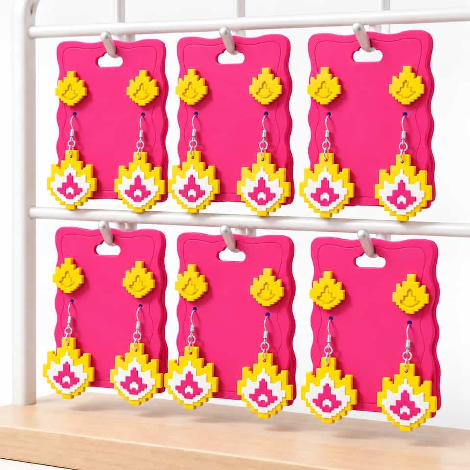 Six pink clay cards hanging by their cloud openings, each displaying yellow relief studs above yellow, white and pink layered dangles.