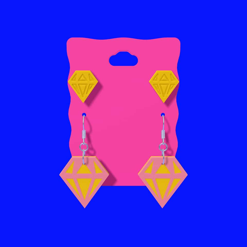 Relief studs above layered drop earrings on a printed display card.