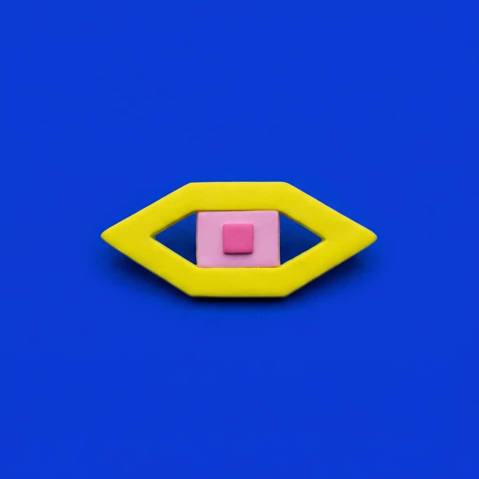 Yellow Polymer Clay Diamond Eye Pin. Brooch made with slab construction with a sanded buffed finish. Build the Yellow Diamond Eye Pin: cut an open yellow eye frame, fit a pink rec…