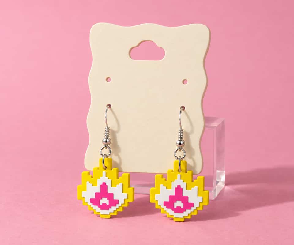 32 mm Pixel Flame drop earrings on a printed Medium display card.