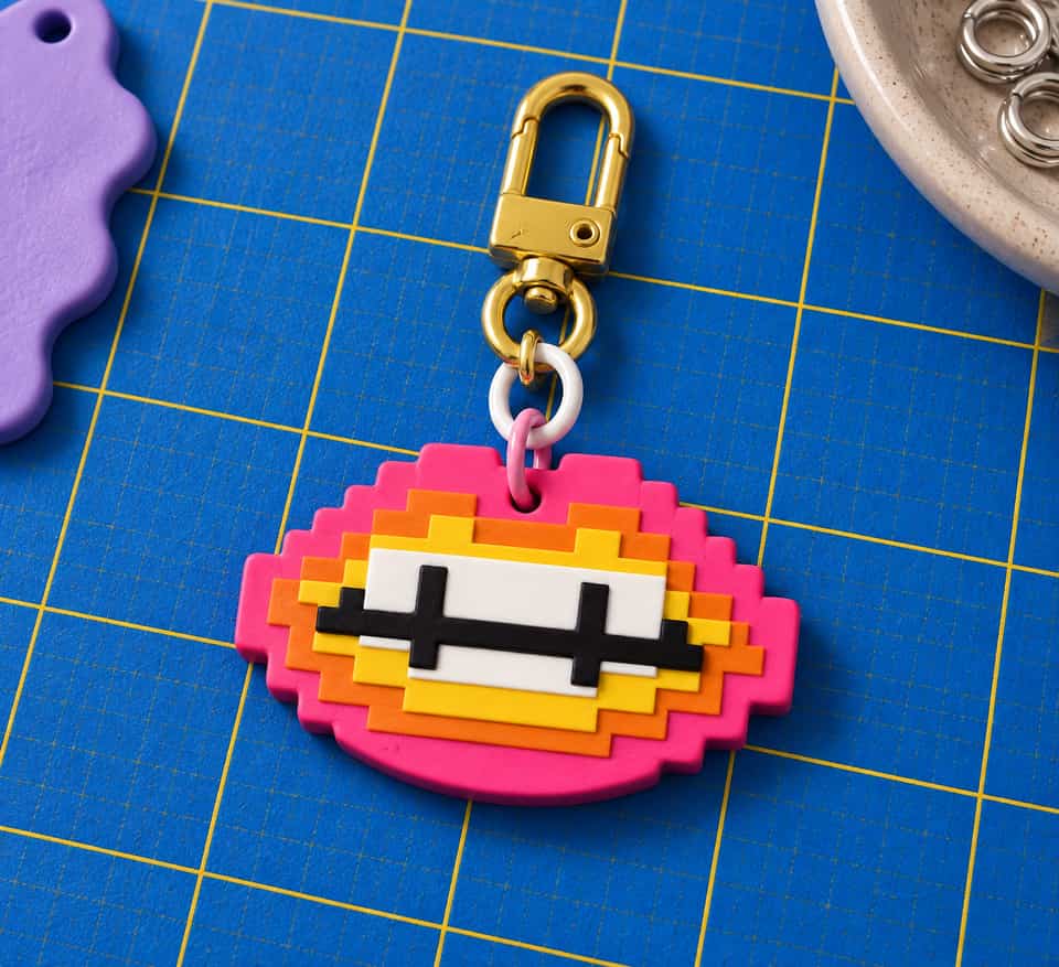 A layered Pixel Lips charm hanging from a snap clasp.