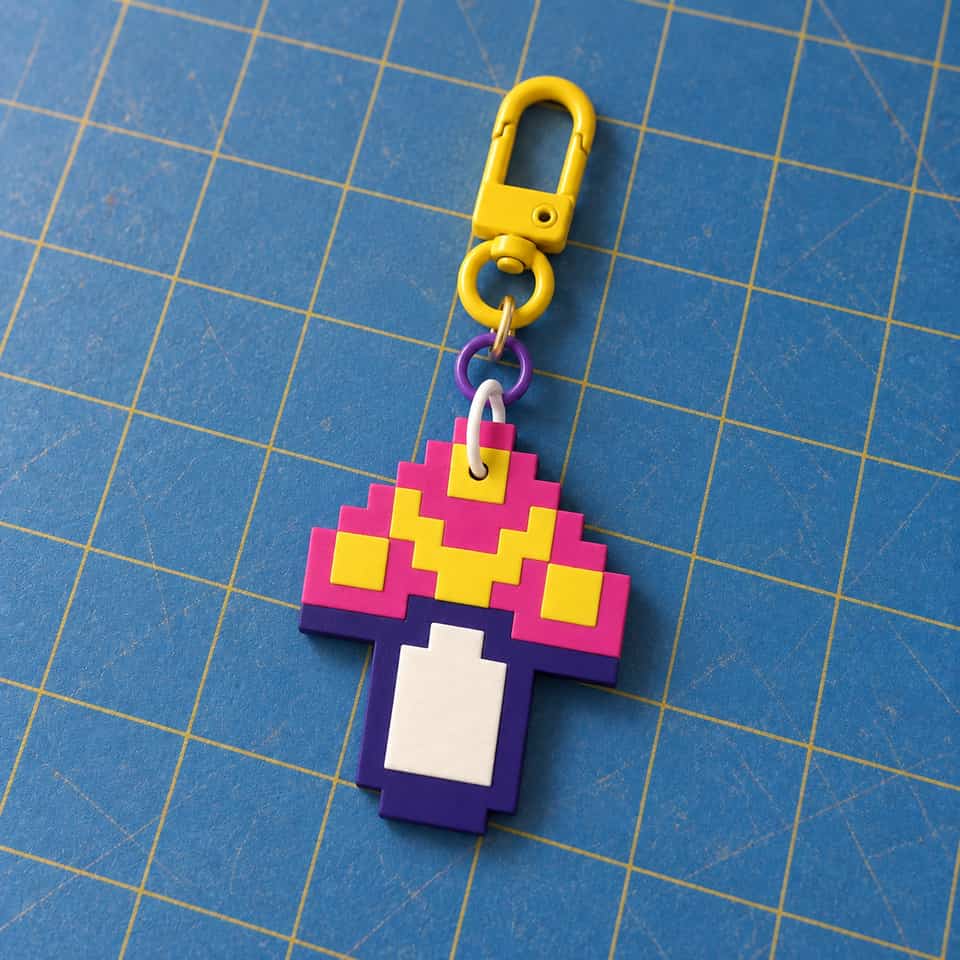 A layered Pixel Mushroom charm hanging from a swivel clasp.