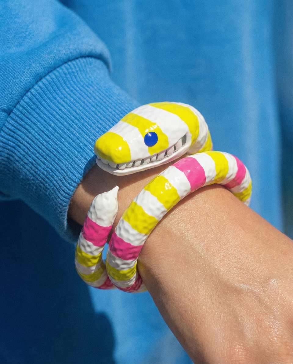 Pink Polymer Clay & Yellow Serpent Coil Bangle shown in styled wear context with size, drape, and hardware visible. Sculpting bracelet with a gloss sealant finish.