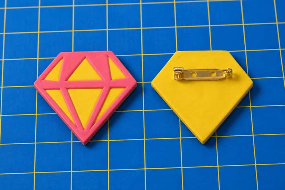 A Faceted Gem brooch with a bar pin on its flat back.