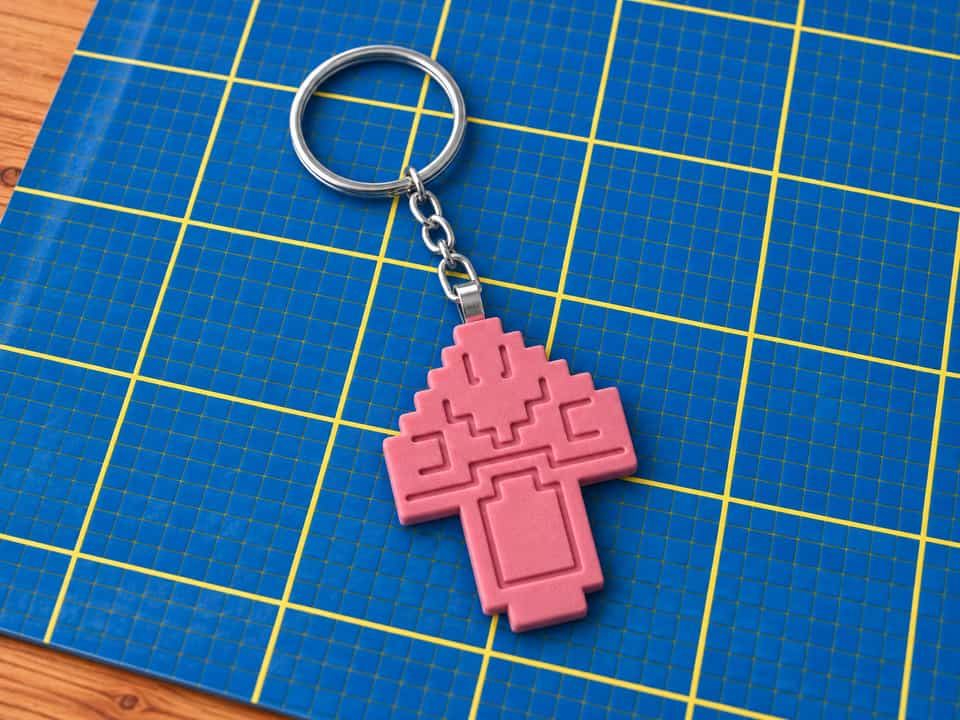 A pink relief mushroom hangs from its glued bail loop. Hang keys from the metal ring, not the clay.