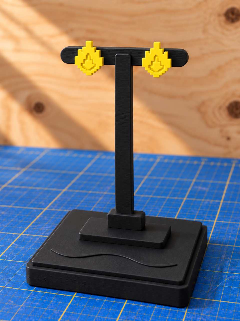A black T-bar displaying a pair of yellow Flame studs.