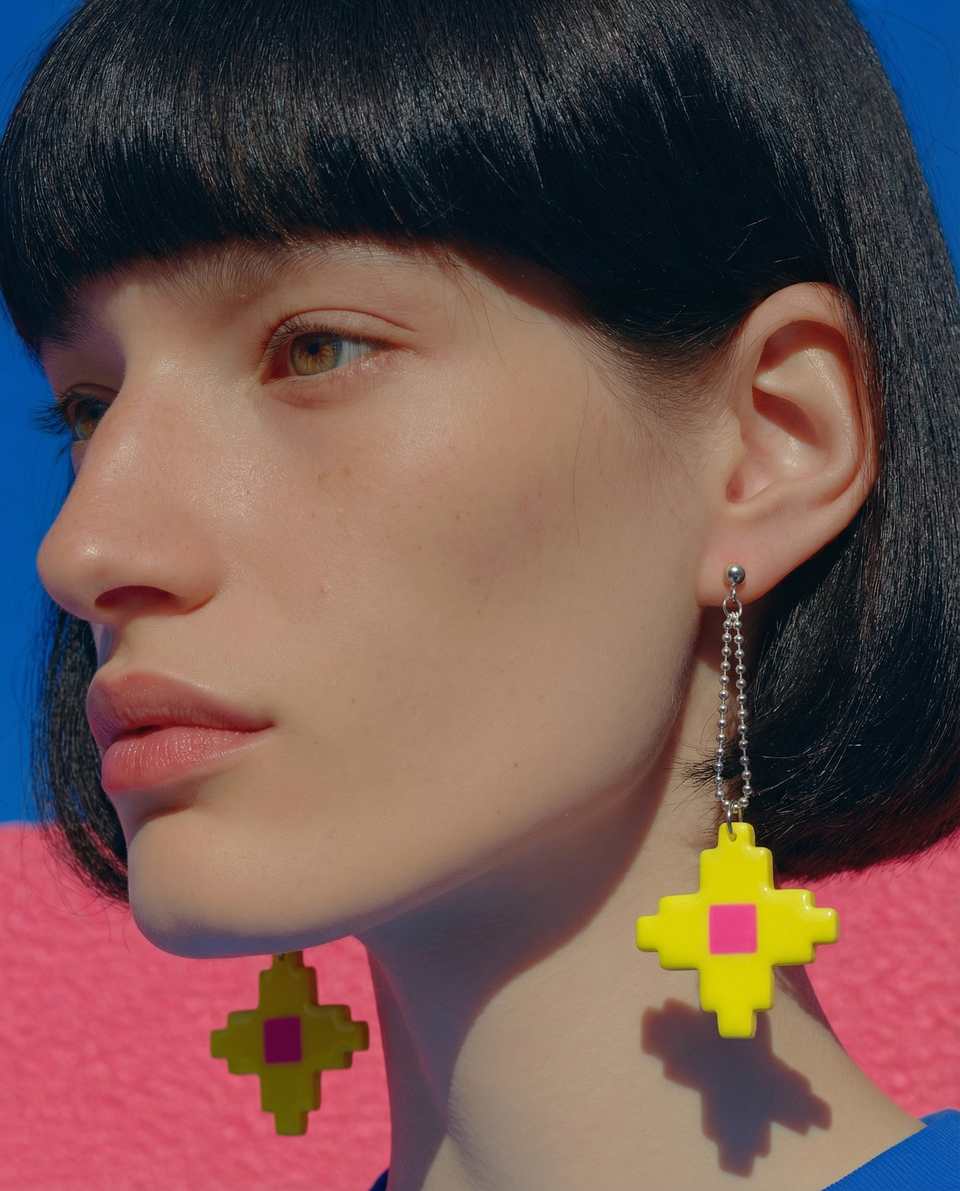 Yellow pixel star earring worn on a longer silver ball chain