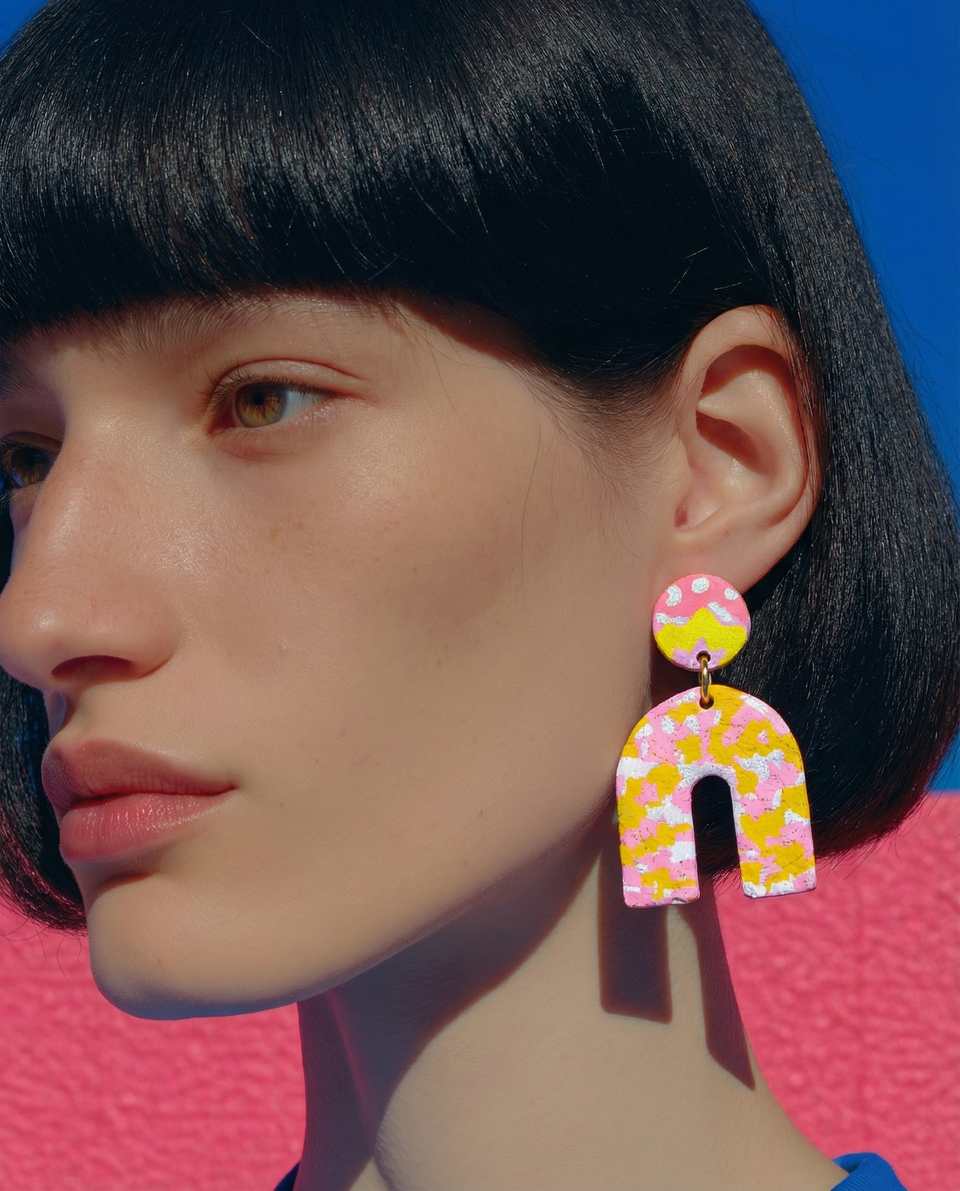 Pink Polymer Clay Leopard Print Arch Dangle Earrings shown in styled wear context with size, drape, and hardware visible. Handmade surface applique earrings with matte sealant fin…