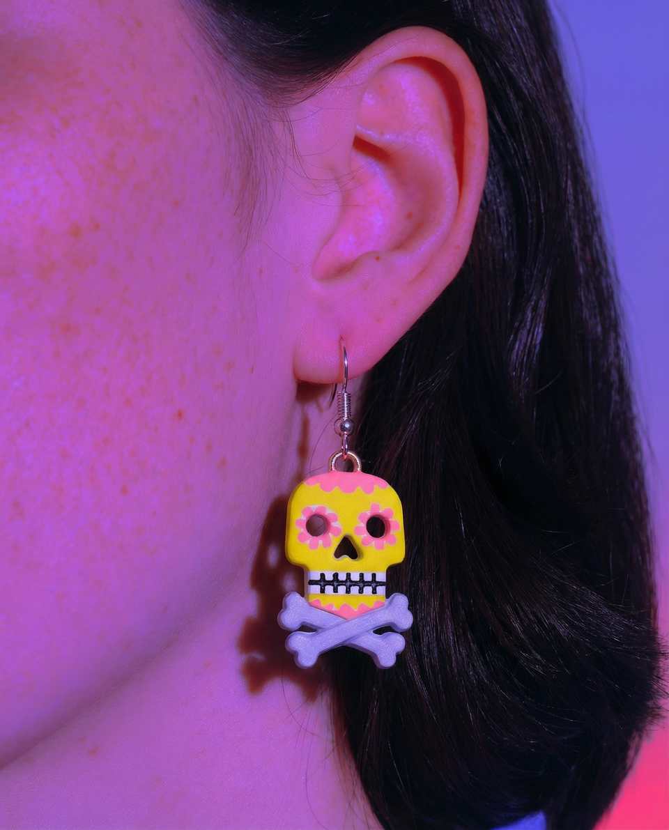 Yellow Polymer Clay & Pink Sugar Skull Dangle Earrings shown in styled wear context with size, drape, and hardware visible. Surface applique earrings, hand-finished with gloss sea…