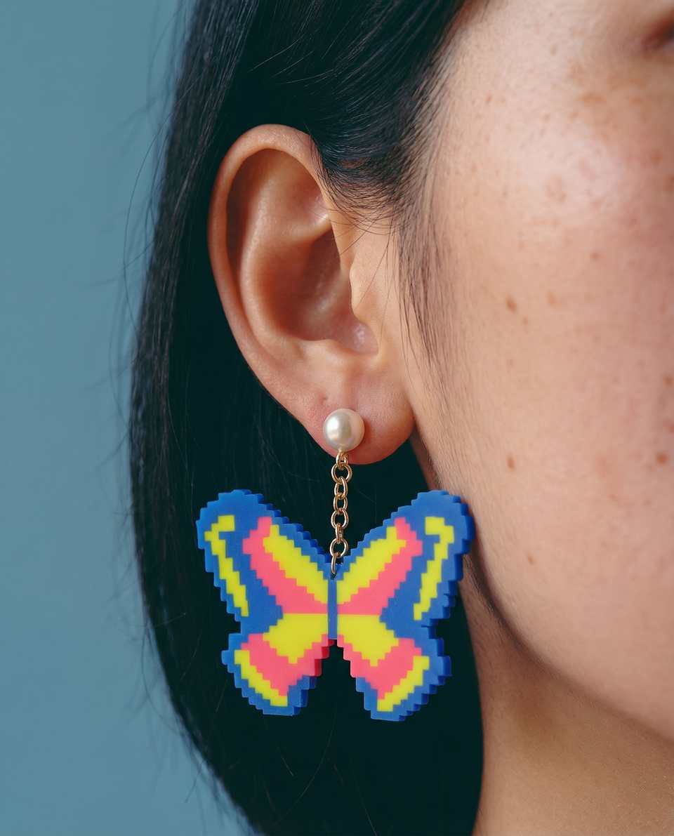 Polymer Clay Blue, Yellow & Pink Pixel Butterfly Pearl Drop Earrings shown in styled wear context with size, drape, and hardware visible. Handmade pixel construction earrings with…
