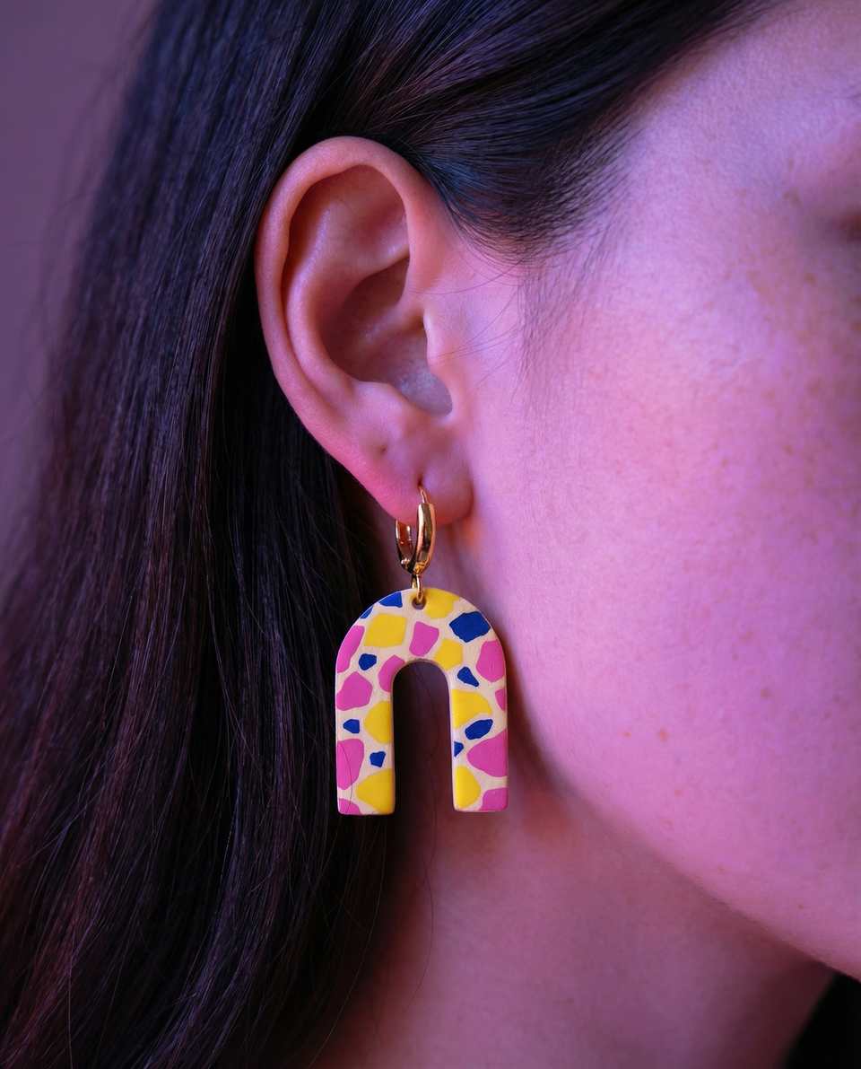 Cream Polymer Clay Terrazzo Arch Huggie Earrings shown in styled wear context with size, drape, and hardware visible. Earrings handmade in terrazzo with matte sealant finish.
