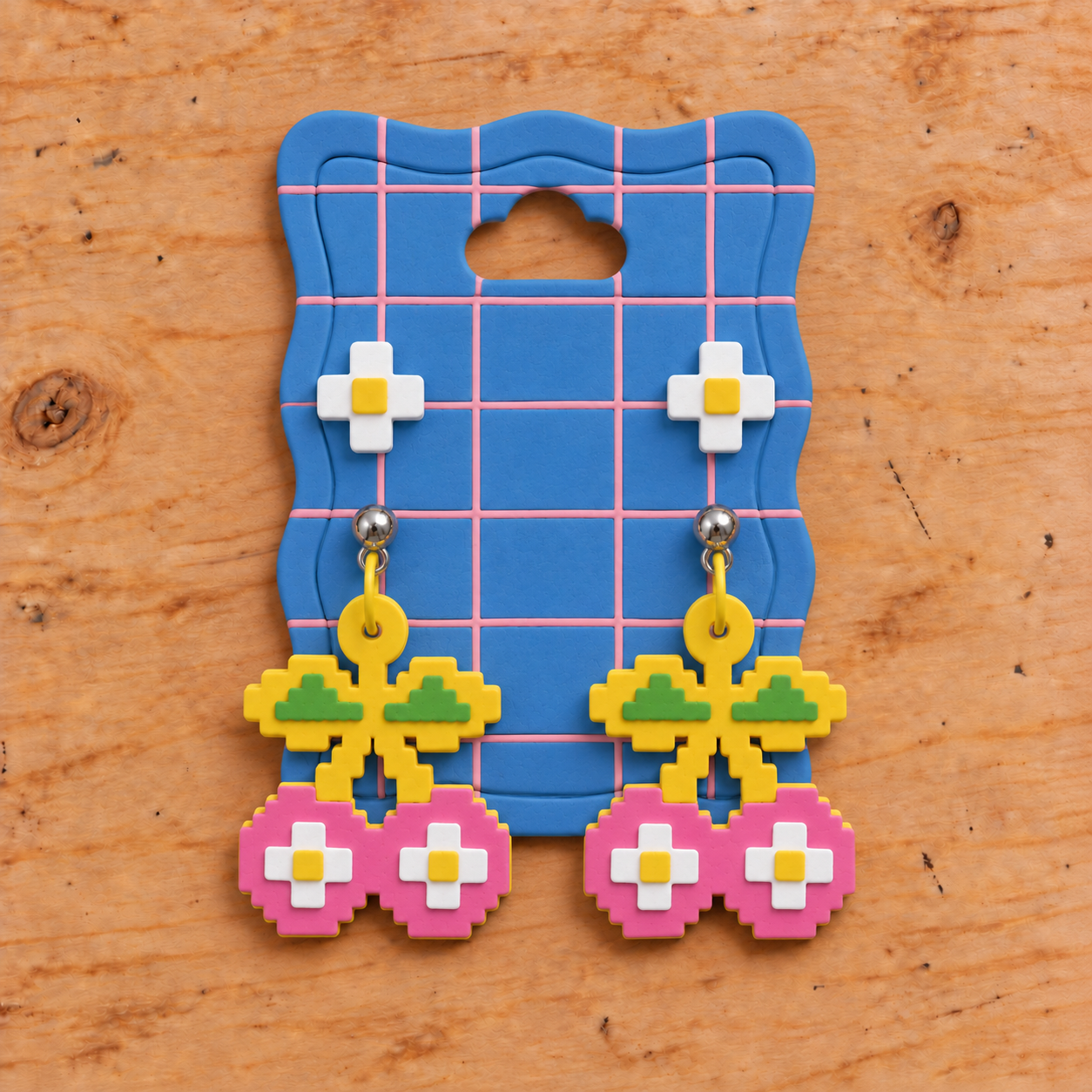 White flower studs and matching Cherry drops arranged on a blue card with pink lines.